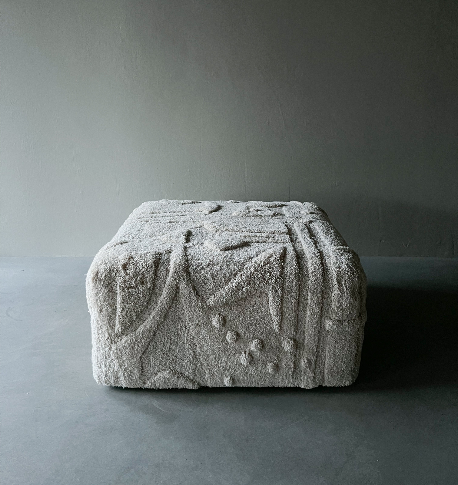 minimalistic tufted beige ecru pouf with geometric relief design